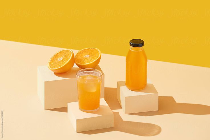ORANGE JUICE PRODUCT PHOTOSHOOT WITH 2 CUT PIECES OF A OREANGE